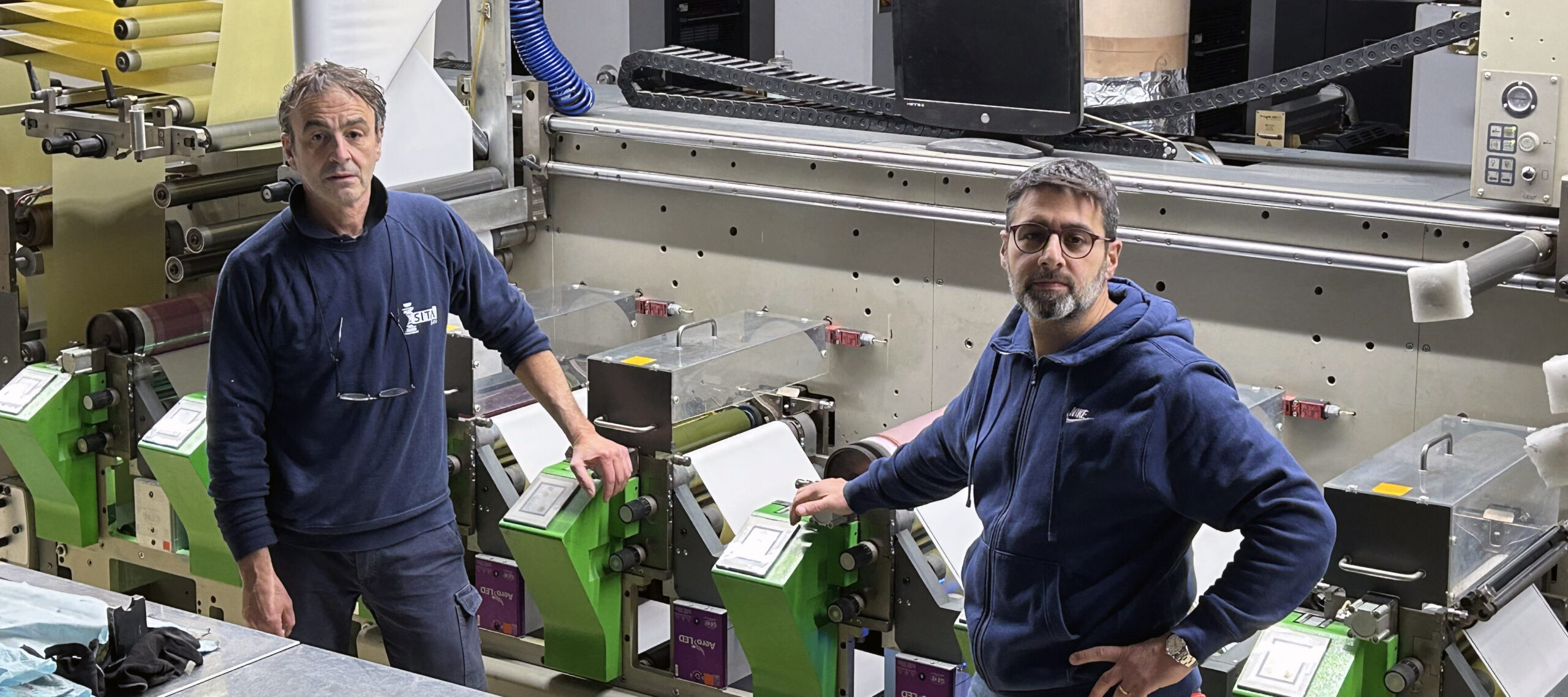 Stefano Masocco and Gianluigi De Blasio with one of their Bobst presses, which is installed with a GEW ArcLED system.